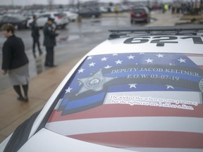 A McHenry County Sheriff's vehicle serving as a memorial car is parked outside before funeral services for slain McHenry County Sheriff's Deputy Jacob Keltner on Wednesday, March 13, 2019, at Woodstock North High School in Woodstock, Ill. Keltner was shot and killed while trying to serve an arrest warrant at a hotel on March 7, 2019.