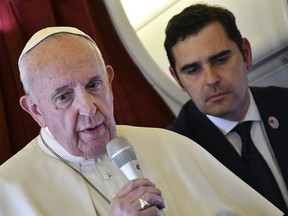 Pope Francis, flanked by interim director of Holy See Press Office, Alessandro Gisotti, speaks to reporters on board the flight back to Rome from a two-day trip to Morocco, Sunday, March 31, 2019.  Francis sought Sunday to encourage greater fraternity between Christians and Muslims in Morocco, telling his flock that showing the country's Muslim majority they are part of the same human family will help stamp out extremism.