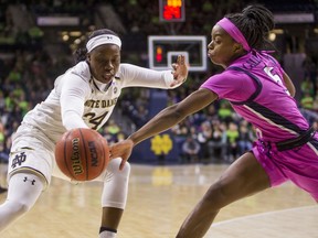 Notre Dame's Arike Ogunbowale (24) and Virginia's Khyasia Caldwell (5) compete for the ball during the first half of an NCAA college basketball game Sunday, March 3, 2019, in South Bend, Ind.
