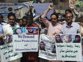 Pakistani civil society activists call for protection of Hindu girls at a protest in Hyderabad, Pakistan, Tuesday, March 26, 2019. A court in Islamabad has ordered protection for two teenage sisters from the minority Hindu community as investigators widen a probe to determine whether the girls were abducted and forced to convert and marry two Muslims. The Islamabad High Court issued the order on Tuesday. Placard at right reads, "Justice for the families of Reena, Raveena and Soniya."