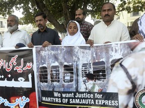 Relatives of victims of a 2007 train explosion in India hold a protest in Lahore, Pakistan, Monday, March 25, 2019. Family members of Pakistanis killed and injured in an Indian train explosion protested an Indian court's acquittal of four Hindus charged with triggering the blasts 12 years ago, which killed 68 passengers.