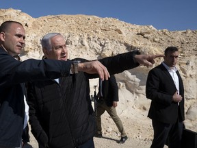 Israel's Prime Minister Benjamin Netanyahu, accompanied by aides and security personnel, visits the southern border with Egypt at Nitzana, Israel, in the Negev Desert, Thursday, March 7, 2019.