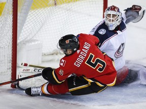 Columbus Blue Jackets goalie Sergei Bobrovsky, right, blocks the net on Calgary Flames' Mark Giordano during first period NHL hockey action in Calgary, Tuesday, March 19, 2019.THE CANADIAN PRESS/Jeff McIntosh