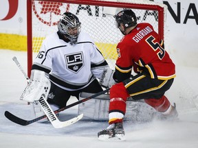 Los Angeles Kings goalie Jack Campbell, left, blocks the net on Calgary Flames' Mark Giordano during second period NHL hockey action in Calgary, Monday, March 25, 2019.THE CANADIAN PRESS/Jeff McIntosh