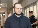 Joshua Boyle is escorted to speak to reporters at Toronto's Pearson International Airport on Oct. 13, 2017.