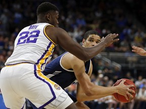 Yale 's Paul Atkinson, right, looks for a shot over LSU's Darius Days (22) during the first half of a first round men's college basketball game in the NCAA Tournament in Jacksonville, Fla., Thursday, March 21, 2019.