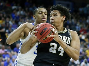 Wofford forward Keve Aluma (24) looks for a path to the basket against Kentucky's Keldon Johnson during the first half of a second-round game in the NCAA men's college basketball tournament in Jacksonville, Fla., Saturday, March 23, 2019.