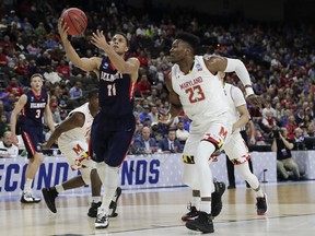 Belmont 's Kevin McClain (11) goes up for a shot over Maryland 's Bruno Fernando (23) during the first half of a first round men's college basketball game in the NCAA Tournament in Jacksonville, Fla., Thursday, March 21, 2019.