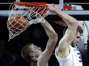 Kansas State forward Dean Wade, right, dunks behind his head over Oklahoma forward Brady Manek, left, during the first half of an NCAA college basketball game in Manhattan, Kan., Saturday, March 9, 2019.