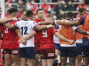 Players offer a silent prayer for victims of a mass shooting at New Zealand before their Super Rugby match between Sunwolves and Reds in Tokyo, Saturday, March 16, 2019.