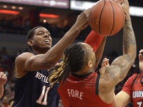Notre Dame forward Juwan Durham (11) battles with Louisville guard Khwan Fore (4) for a rebound during the first half of an NCAA college basketball game in Louisville, Ky., Sunday, March 3, 2019.