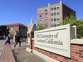 FILE - This Tuesday, March 12, 2019 file photo shows the University Village area of the University of Southern California in Los Angeles. The university says a review of students possibly connected to a college admissions bribery scandal could lead to expulsions. The university said in a statement Monday, March 18, 2019, it has placed holds on the accounts of those students, which prevents them from registering for classes or acquiring transcripts while their cases are under review.