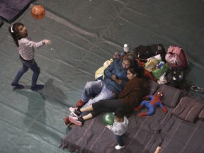 FILE - In this Feb. 19, 2019, file photo, migrants who are awaiting their chance to request asylum in the U.S. pass the time inside a shelter in Bachilleres gymnasium in Ciudad Juarez, Mexico. The Trump administration's effort to make asylum seekers wait in Mexico explicitly targets Spanish-speakers and people from Latin America, according to internal guidelines of a highly touted strategy to address the burgeoning number of Central Americans arriving at U.S. borders.