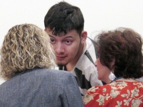 FILE - In this Jan. 24, 2019 file photo, Wilber Ernesto Martinez-Guzman, 19, of El Salvador, talks to his public defender and interpreter during his initial appearance in Carson City Justice Court in Carson City, Nev. A detective says the Salvadoran immigrant charged with four Nevada murders told police he robbed and killed his elderly victims during a 10-day rampage in January because he needed money to buy methamphetamine. According to a grand jury transcript obtained by The Associated Press, the Reno detective testified last week that Martinez-Guzman broke into tears and repeatedly called himself an "idiot" before confessing to the murders.