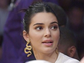 FILE - In this Jan. 29, 2019 file photo, Kendall Jenner watches an NBA basketball game between the Los Angeles Lakers and the Philadelphia 76ers in Los Angeles. U.S. immigration authorities have arrested a Canadian man who has twice been convicted of trespassing at the California home of model and Kardashian family member Kendall Jenner. U.S. Immigration and Customs Enforcement said Friday, March 29, 2019 that 38-year-old John Ford was recently arrested in the parking lot of an Albuquerque motel after agents received a tip that he was in New Mexico.