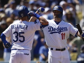 Los Angeles Dodgers' Cody Bellinger, left, celebrates with A.J. Pollock after hitting a solo home run during the third inning of a baseball game against the Arizona Diamondbacks in Los Angeles, Sunday, March 31, 2019.