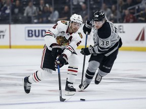 Chicago Blackhawks defenseman Duncan Keith (2) reaches for the puck as Los Angeles Kings forward Carl Grundstrom (38) defends during the first period of an NHL hockey game Saturday, March 30, 2019, in Los Angeles.