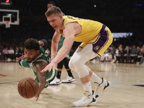 Los Angeles Lakers' Moritz Wagner, right, of Germany, and Boston Celtics' Marcus Smart, left, fight for a loose ball during the first half of an NBA basketball game, Saturday, March 9, 2019, in Los Angeles.