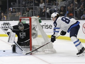 Los Angeles Kings goaltender Jack Campbell, left, stops a shot from Winnipeg Jets' Sami Niku during the first period of an NHL hockey game Monday, March 18, 2019, in Los Angeles.