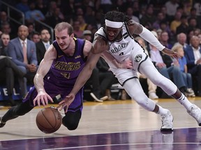 Los Angeles Lakers guard Alex Caruso, left, and Brooklyn Nets forward DeMarre Carroll scramble for a loose ball during the first half of an NBA basketball game Friday, March 22, 2019, in Los Angeles.