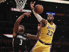 Los Angeles Lakers' LeBron James, right, grabs a rebound against Washington Wizards' Bradley Beal during the first half of an NBA basketball game, Tuesday, March 26, 2019, in Los Angeles.