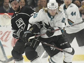 Los Angeles Kings defenseman Alec Martinez, left, and San Jose Sharks left wing Marcus Sorensen vie for the puck during the first period of an NHL hockey game Thursday, March 21, 2019, in Los Angeles.