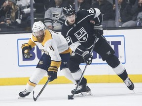 Nashville Predators defenseman Ryan Ellis (4) and Los Angeles Kings forward Dustin Brown (23) vie for the puck during the first period of an NHL hockey game Thursday, March 14, 2019, in Los Angeles.