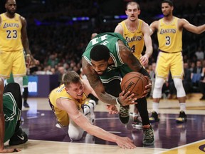 Boston Celtics' Kyrie Irving, right, grabs a loose ball against Los Angeles Lakers' Moritz Wagner during the second half of an NBA basketball game, Saturday, March 9, 2019, in Los Angeles. The Celtics won 120-107.