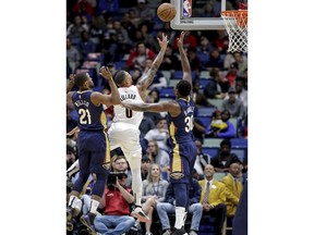 Portland Trail Blazers guard Damian Lillard (0) shoots over New Orleans Pelicans center Julius Randle (30) and forward Darius Miller (21) in the first half of an NBA basketball game in New Orleans, Friday, March 15, 2019.