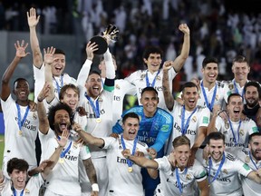 FILE - In this Saturday, Dec. 22, 2018 file photo, Real Madrid players celebrate with the trophy after winning the Club World Cup at Zayed Sport City in Abu Dhabi, United Arab Emirates. FIFA Council members will be asked on Friday March 15, 2019, to approve a pilot of an expanded 24-team Club World Cup in June-July 2021, The Associated Press has learned. A revamp of the current annual December seven-team competition is being pursued by FIFA President Gianni Infantino despite ongoing opposition from Europe, with the long-term vision of the bigger Club World Cup being staged every four years.