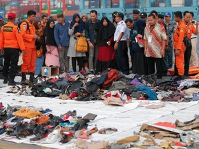 Relatives of passengers on the crashed Lion Air jet check personal belongings retrieved from the waters where the airplane is believed to have crashed, at Tanjung Priok Port in Jakarta, Indonesia, on Oct. 31, 2018.