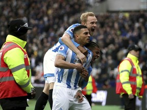 Huddersfield Town's Karlan Grant celebrates scoring his side's third goal of the game with teammates during their English Premier League soccer match against West Ham United at London Stadium in London, Saturday, March 16, 2019.