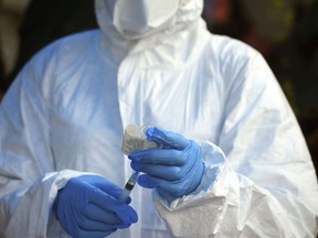 A healthcare worker from the World Health Organization prepares to give an Ebola vaccination.