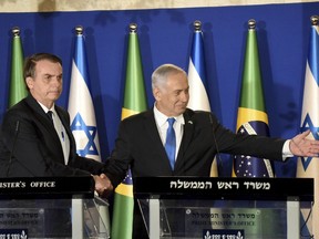 Brazilian President Jair Bolsonaro and Israel Prime Minister Benjamin Netanyahu, right, shake hands during a joint media conference at the prime minister's residence in Jerusalem, Sunday March 31, 2019.  Bolsonaro is in Israel on a four day official visit.