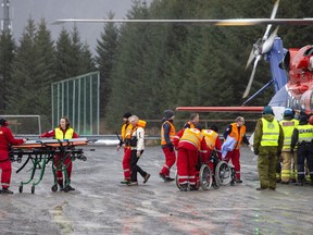 Passengers are helped from a rescue helicopter in Fraena, Norway, Sunday March 24, 2019, after being rescued from the Viking Sky cruise ship. Rescue workers are evacuating more passengers from a cruise ship that had engine problems in bad weather off Norway's western coast while authorities prepare to tow the vessel to a nearby port.