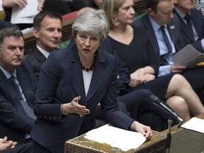 Britain's Prime Minister Theresa May stands to talk to lawmakers inside the House of Commons parliament in London Wednesday March 27, 2019. As Lawmakers sought Wednesday for an alternative to May's unpopular Brexit deal with Europe, with a series of 'indicative votes", May offered to resign from office if her deal is passed by lawmakers at some point and Britain left the European Union.