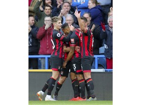 Bournemouth's Callum Wilson, centre, celebrates scoring his side's first goal of the game against Huddersfield, during their English Premier League soccer match at the John Smith's Stadium in Huddersfield, England, Saturday March 9, 2019.