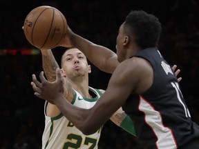 Boston Celtics forward Daniel Theis, left, reaches for the ball in a steal attempt against Washington Wizards center Thomas Bryant during the first quarter of an NBA basketball game Friday, March 1, 2019, in Boston.