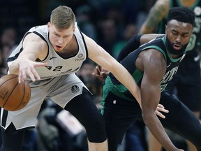 San Antonio Spurs' Davis Bertans (42) and Boston Celtics' Jaylen Brown, right, battle for the ball during the first half of an NBA basketball game in Boston, Sunday, March 24, 2019.