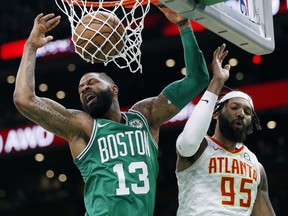 Boston Celtics' Marcus Morris (13) dunks against Atlanta Hawks' DeAndre' Bembry (95) during the first half of an NBA basketball game in Boston, Saturday, March 16, 2019.