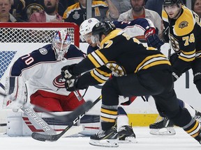 Boston Bruins' Patrice Bergeron, foreground, scores on Columbus Blue Jackets' Joonas Korpisalo (70) during the first period of an NHL hockey game in Boston, Saturday, March 16, 2019.