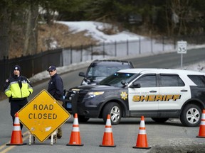 Berkshire County Sheriff Department officers close off the road Wednesday, March 13, 2019, in Sheffield, Mass., to a home where investigators work at the scene of a house fire that killed five people.