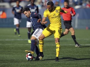 New England Revolution's Carles Gil, left, battles Columbus Crew's Artur (8) for the ball during the first half of an MLS soccer game, Saturday, March 9, 2019, in Foxborough, Mass.