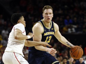 Michigan forward Ignas Brazdeikis, right, of Canada, drives against Maryland guard Anthony Cowan Jr. in the first half of an NCAA college basketball game, Sunday, March 3, 2019, in College Park, Md.