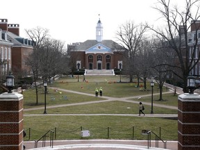 In this Feb. 26, 2019 photo, people walk across a quad at Johns Hopkins University in Baltimore.  This private research institution with one of the world's foremost medical schools, wants to create an armed police force similar to those patrolling numerous other U.S. urban colleges and universities.  But a renewed effort to establish a sworn force is stirring intense debate about Baltimore's persistent racial divide and the university's complicated relationship with its home city.