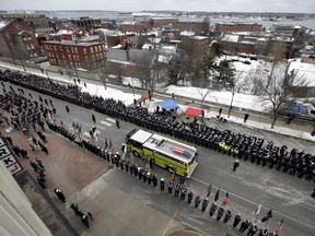 The casket of Berwick Fire Capt. Joel Barnes is carried atop a fire truck during a procession leading to memorial service, Sunday, March 10, 2019, in Portland, Maine. Barnes was fatally injured while shielding another firefighter from flames.