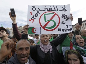 A demonstrator holds up a sign that reads, "no to a 5th term" during a protest to denounce President Abdelaziz Bouteflika's bid for a fifth term, in Marseille, southern France, Sunday, March 3, 2019. Algeria's Constitutional Council has been placed under high security as President Abdelaziz Bouteflika's bid for a fifth term is due to be formally submitted.