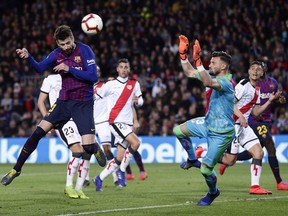 FC Barcelona's Gerard Pique, left, heads for the ball to score his side's first goal during the Spanish La Liga soccer match between FC Barcelona and Rayo Vallecano at the Camp Nou stadium in Barcelona, Spain, Saturday, March 9, 2019.