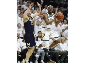 Michigan State guard Cassius Winston (5) passes the ball as Michigan forward Ignas Brazdeikis (13) defends during the first half of an NCAA college basketball game Saturday, March 9, 2019, in East Lansing, Mich.