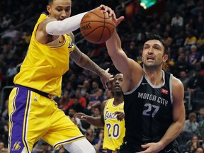 Los Angeles Lakers forward Kyle Kuzma and Detroit Pistons center Zaza Pachulia (27) reach for the rebound during the second half of an NBA basketball game, Friday, March 15, 2019, in Detroit.